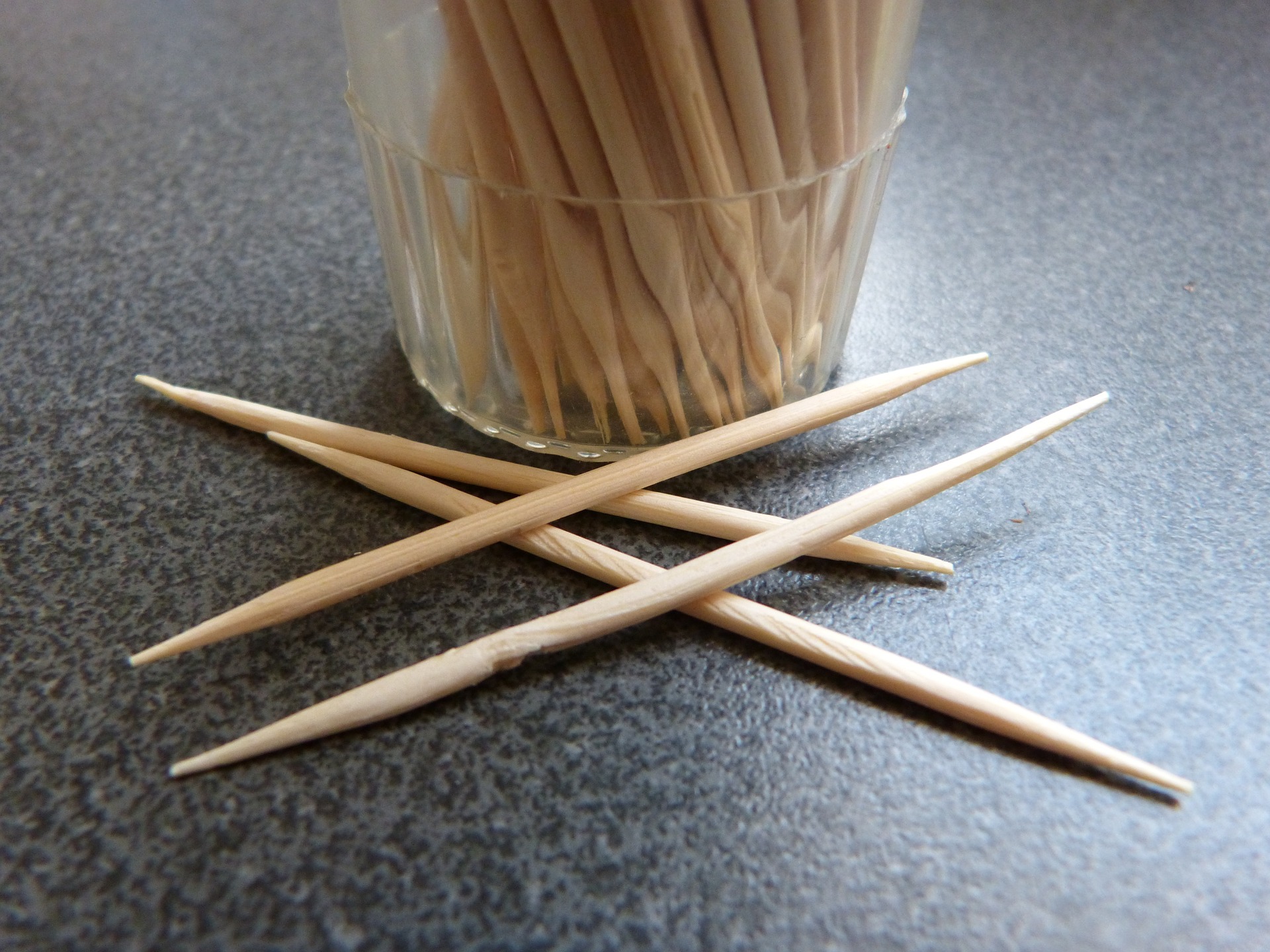 Cup of toothpicks on a table.