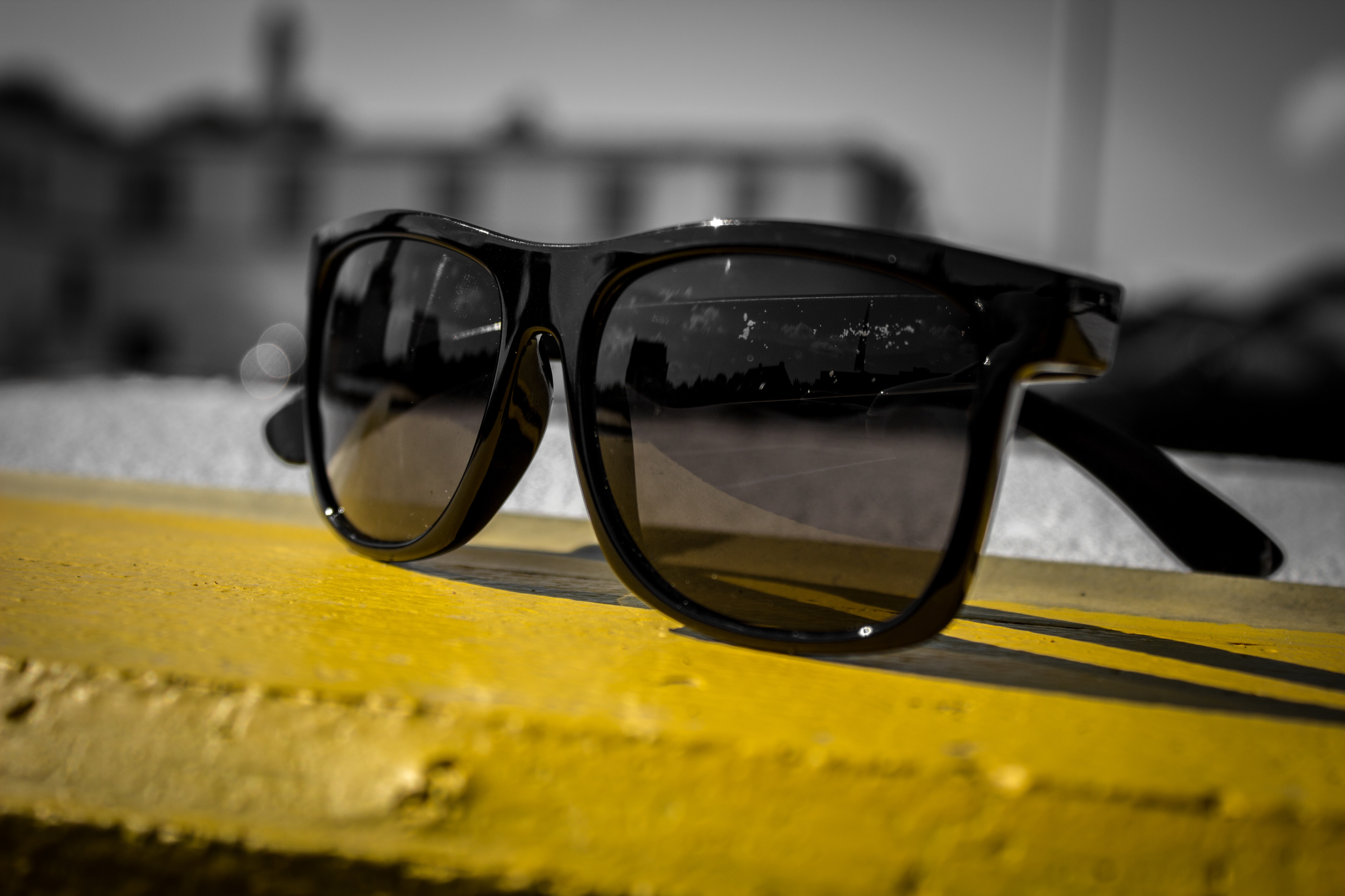 Sunglasses on a yellow surface.