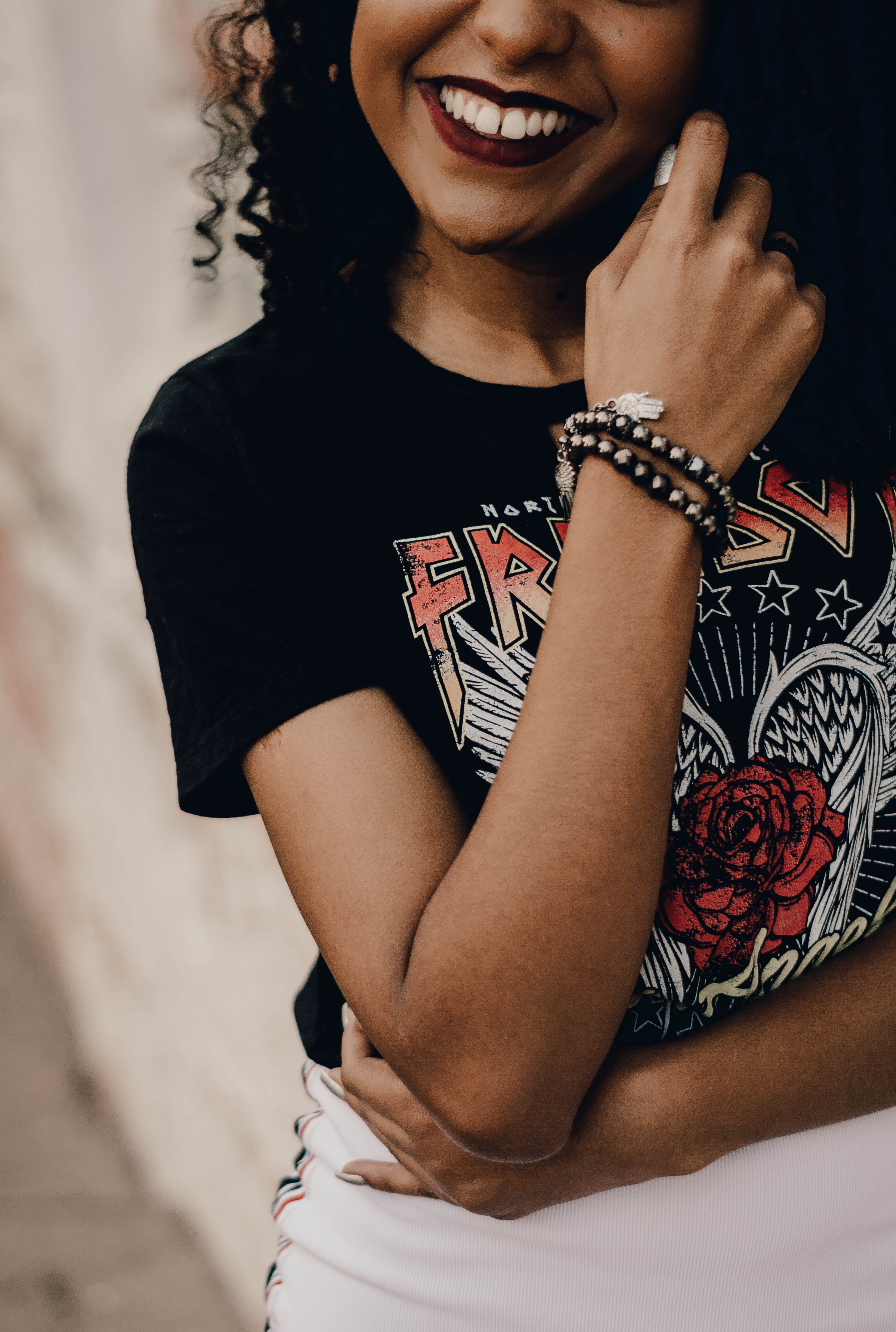 Woman wearing a logo shirt and a bracelet.