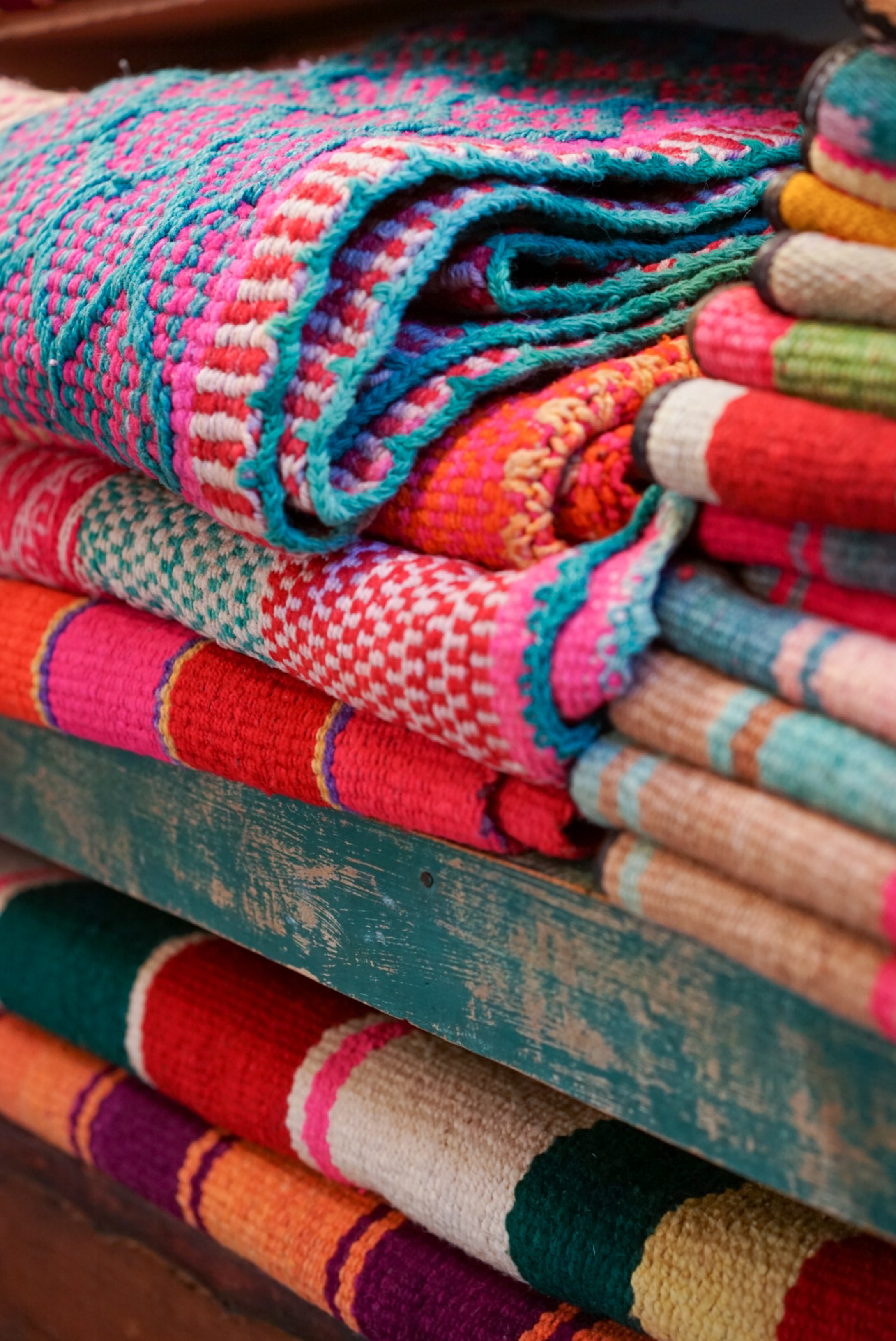 Pile of colorful blankets at a market.