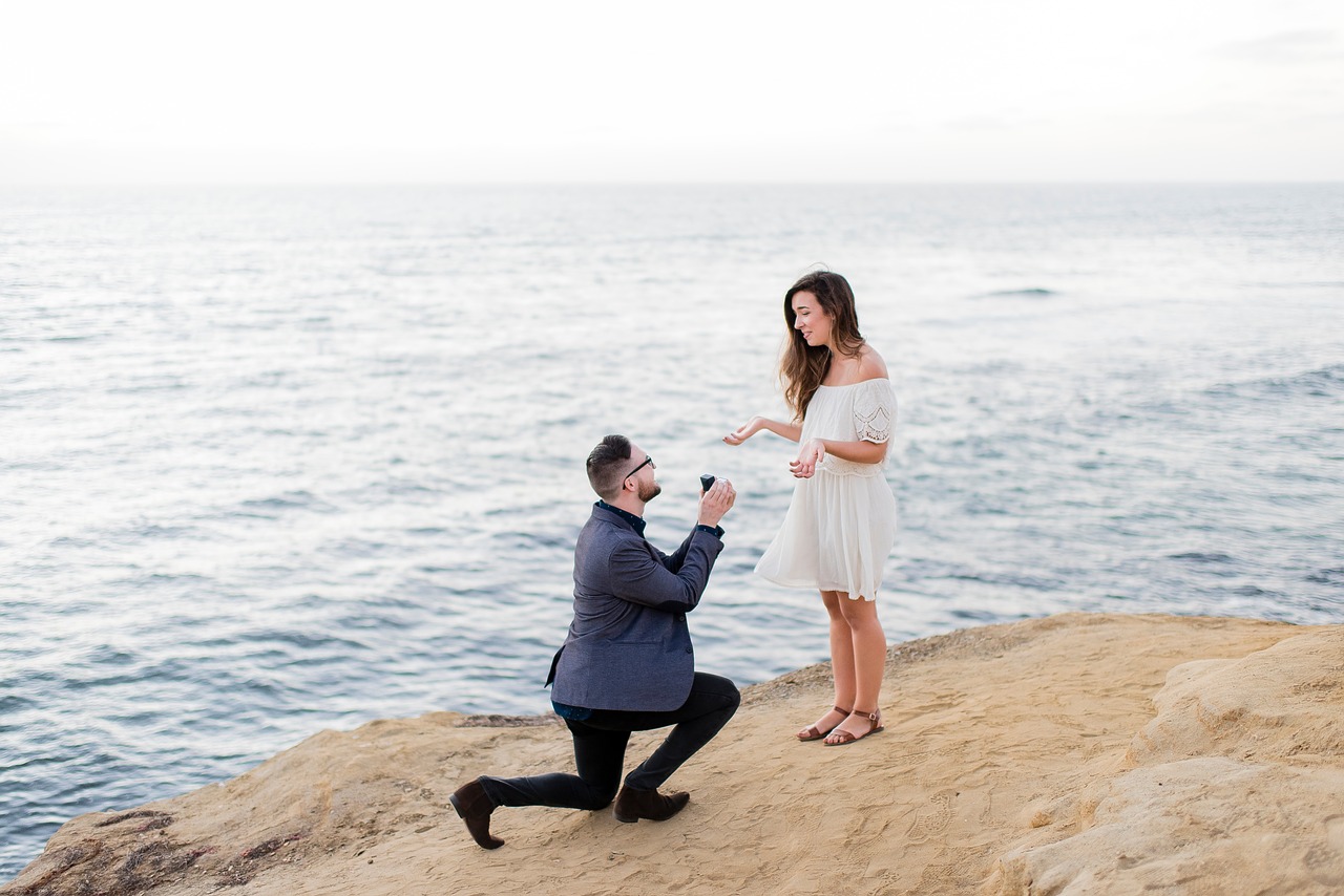 Man proposing to a woman on a beach.