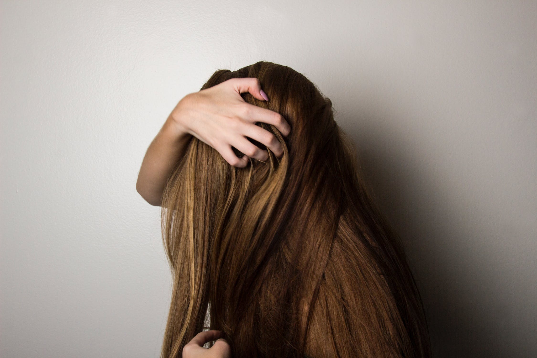 Woman holding her hand over her hair.