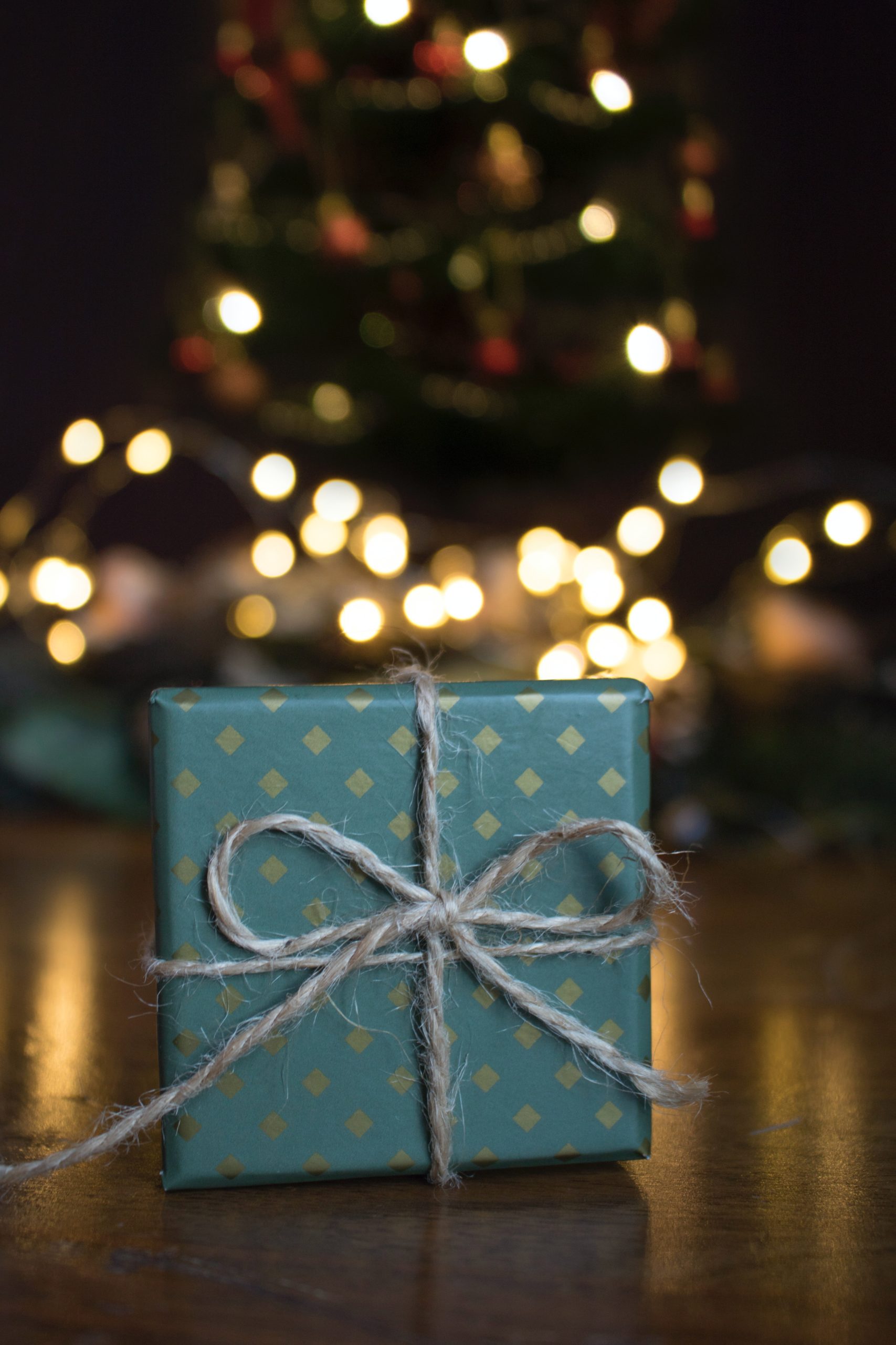 Present wrapped in front of a Christmas tree
