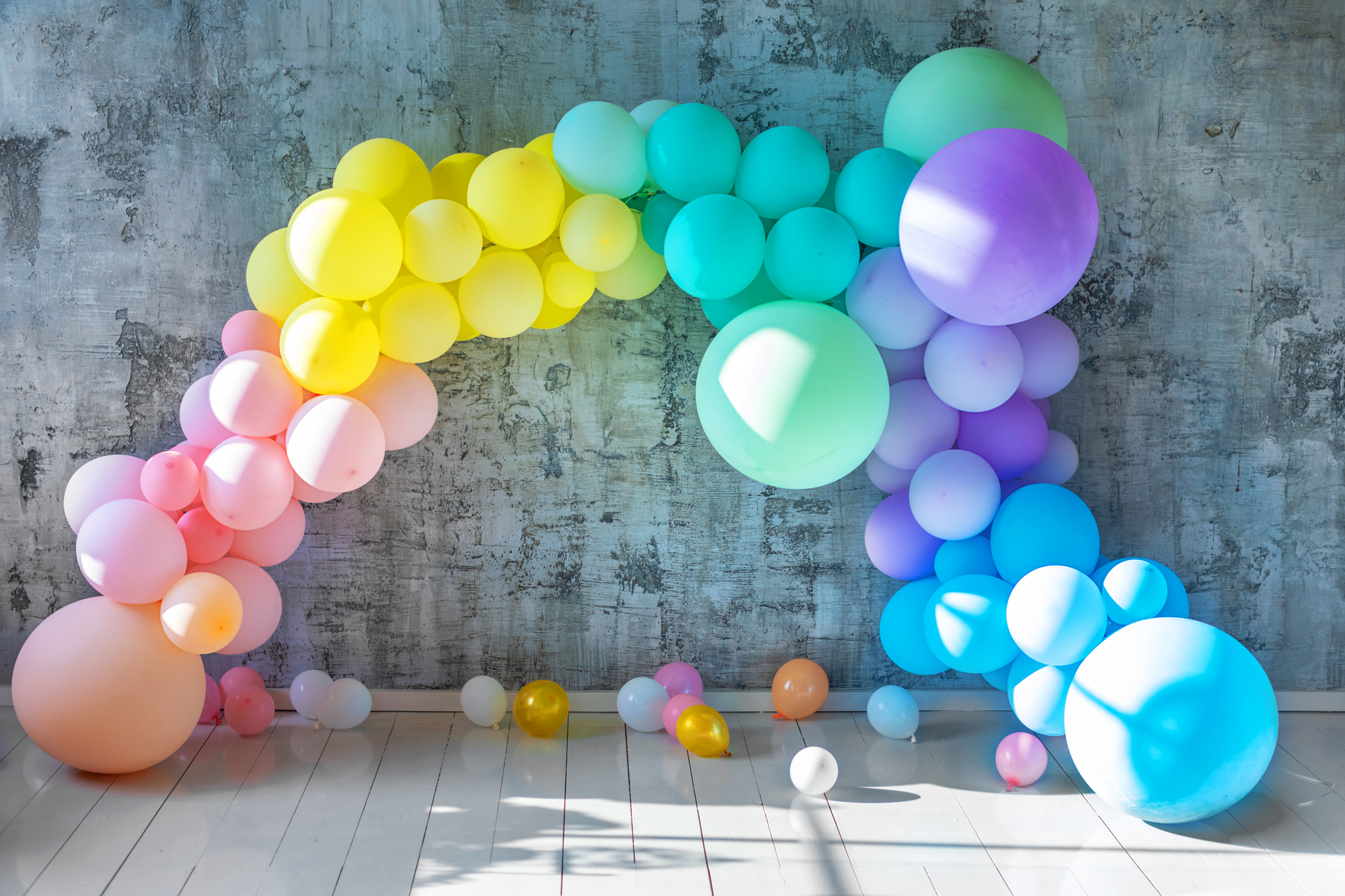 A pastel rainbow color balloon arch.