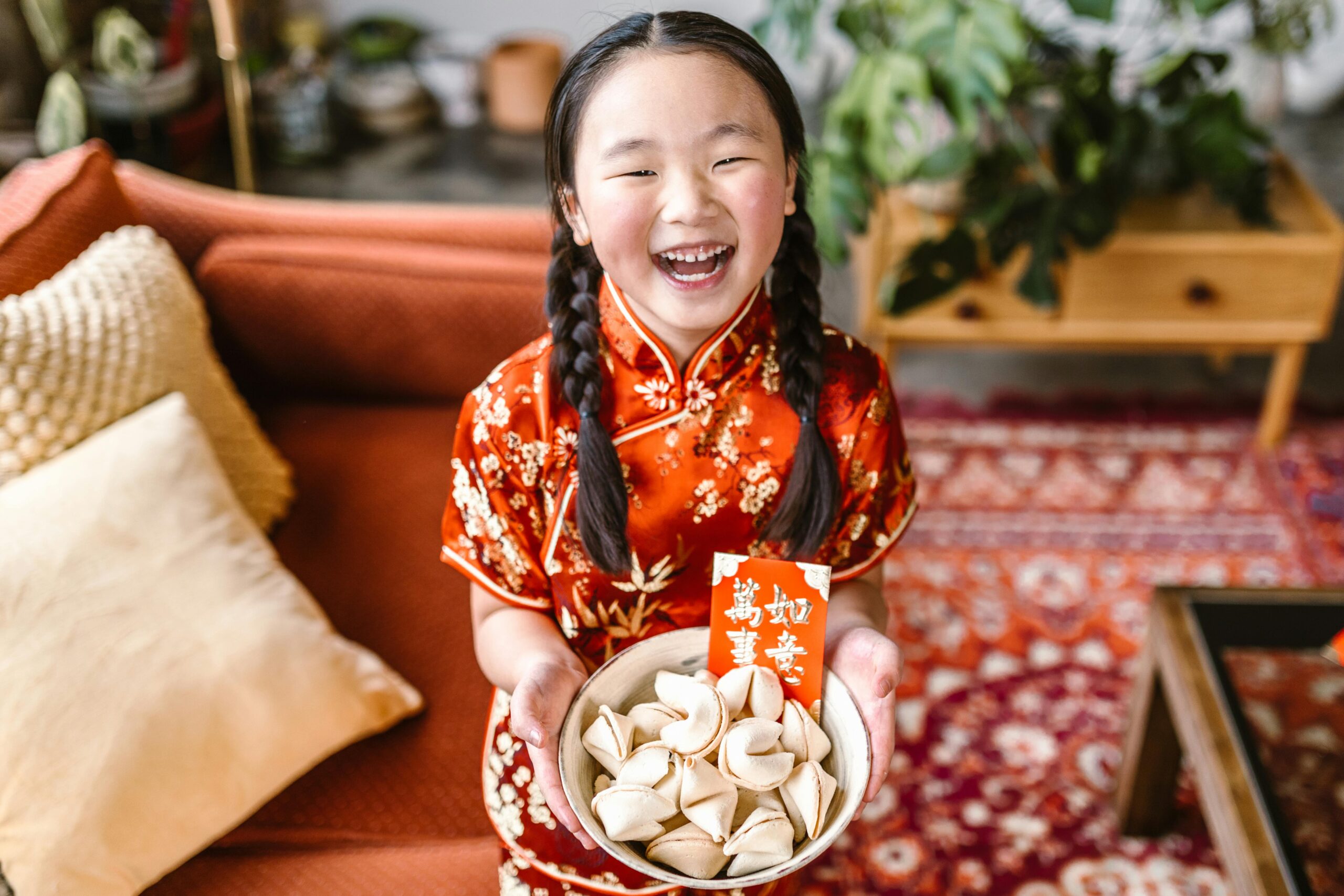 Lunar New Year celebration with a girl holding a bowl of fortune cookies.